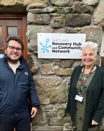 Highlands and Islands Spotlight Project Lead Luis Yanes smiles with a human rights defender outside of the Recovery Hub and Community Network in Shetland