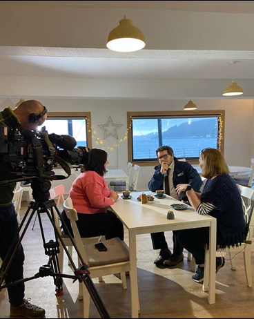 Highlands and Islands Spotlight Lead Luis Yanes and colleague Dr Alison Hosie sit across a table from Channel 4’s Kathryn Samson. A camera operators stands recording the conversation.